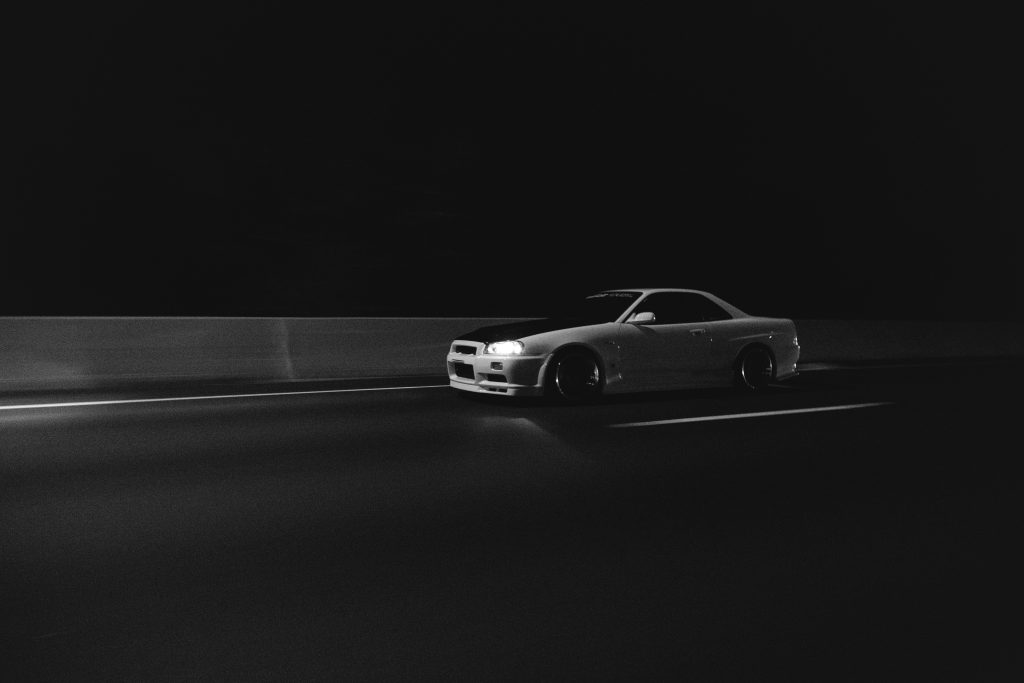 black and white image of a car driving on the motorway